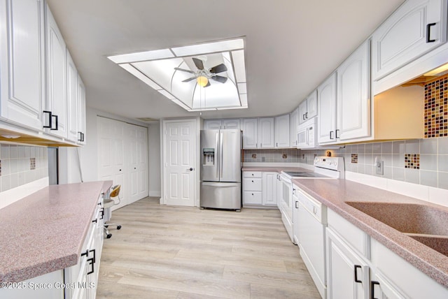 3609 S Banana River Blvd Unit C511, Cocoa Beach, FL 32931 - kitchen with white appliances, a ceiling fan, light wood-style flooring, decorative backsplash, and white cabinetry