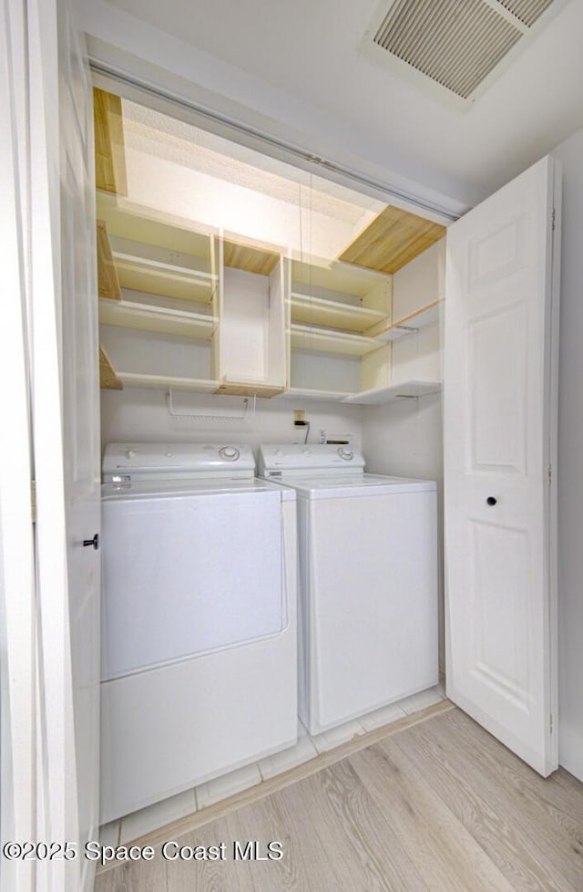 3609 S Banana River Blvd Unit C511, Cocoa Beach, FL 32931 - washroom featuring independent washer and dryer and light wood-style flooring
