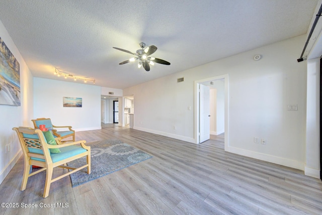 3609 S Banana River Blvd Unit C511, Cocoa Beach, FL 32931 - sitting room with wood finished floors, a ceiling fan, and a textured ceiling
