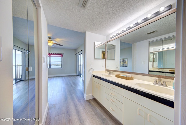 3609 S Banana River Blvd Unit C511, Cocoa Beach, FL 32931 - full bath featuring wood finished floors, double vanity, a textured ceiling, and a ceiling fan