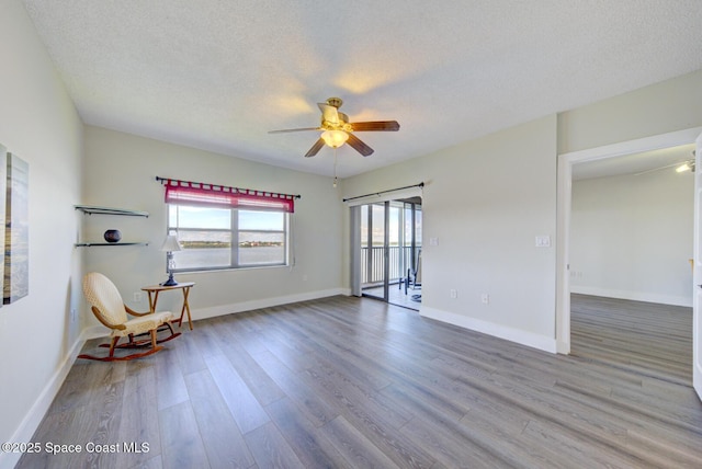 3609 S Banana River Blvd Unit C511, Cocoa Beach, FL 32931 - sitting room featuring a ceiling fan, wood finished floors, and a textured ceiling
