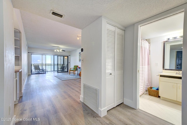 3609 S Banana River Blvd Unit C511, Cocoa Beach, FL 32931 - hallway featuring light wood-style flooring and a textured ceiling