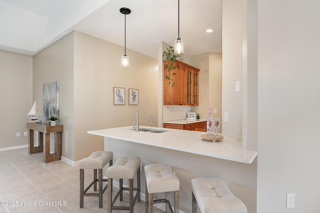 130 Cameron St SE, Palm Bay, FL 32909 - kitchen with brown cabinetry, a breakfast bar area, glass insert cabinets, pendant lighting, and a peninsula