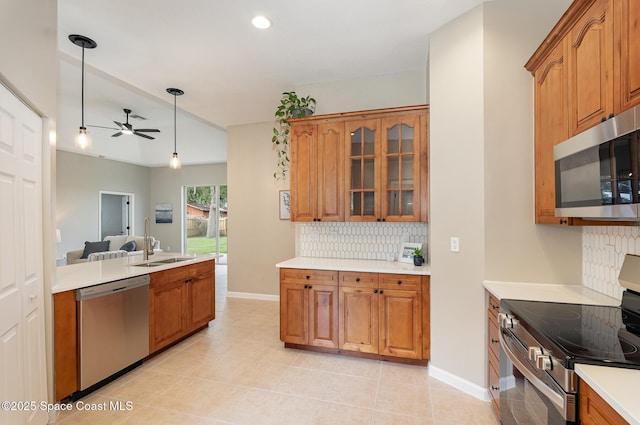 130 Cameron St SE, Palm Bay, FL 32909 - kitchen featuring appliances with stainless steel finishes, tasteful backsplash, brown cabinetry, a ceiling fan, and recessed lighting