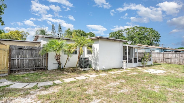 2515 Andrews Ave, Melbourne, FL 32935 - back of property with a sunroom, stucco siding, and a fenced backyard