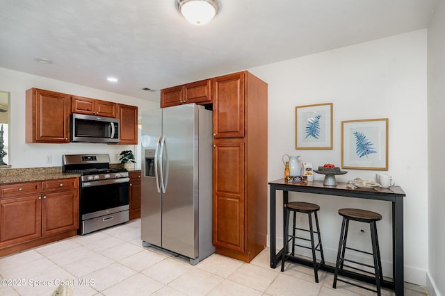 2515 Andrews Ave, Melbourne, FL 32935 - kitchen featuring appliances with stainless steel finishes, brown cabinets, light tile patterned flooring, recessed lighting, and dark stone countertops