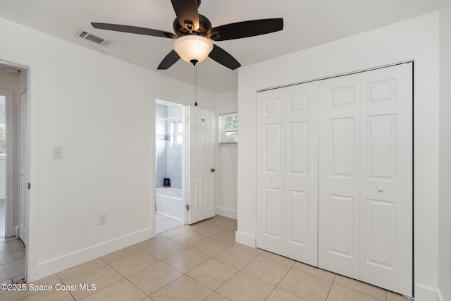 2515 Andrews Ave, Melbourne, FL 32935 - unfurnished bedroom with light tile patterned floors, a closet, ensuite bath, and ceiling fan