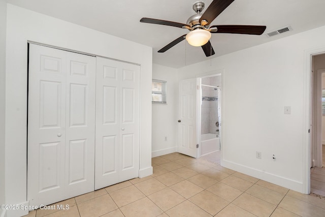 2515 Andrews Ave, Melbourne, FL 32935 - unfurnished bedroom with light tile patterned flooring, a closet, connected bathroom, and a ceiling fan