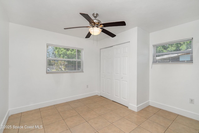 2515 Andrews Ave, Melbourne, FL 32935 - unfurnished bedroom featuring multiple windows, light tile patterned floors, a closet, and a ceiling fan