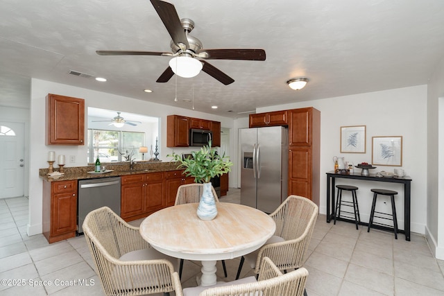 2515 Andrews Ave, Melbourne, FL 32935 - kitchen with stainless steel appliances, light tile patterned floors, ceiling fan, recessed lighting, and brown cabinets