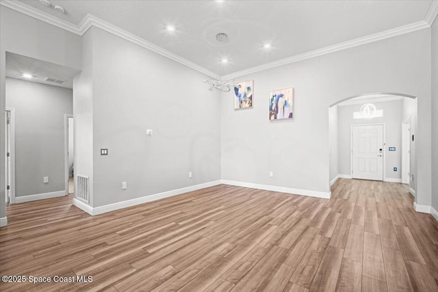 922 Raleigh Rd SE, Palm Bay, FL 32909 - spare room featuring light wood-style flooring, ornamental molding, arched walkways, and recessed lighting