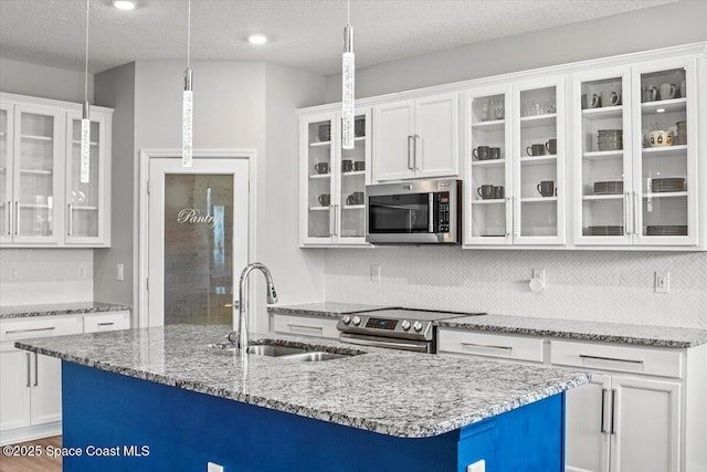 922 Raleigh Rd SE, Palm Bay, FL 32909 - kitchen with appliances with stainless steel finishes, white cabinets, decorative backsplash, decorative light fixtures, and a textured ceiling