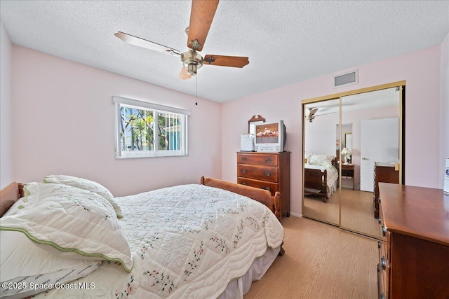 443 Aruba Ct, Satellite Beach, FL 32937 - bedroom with light wood finished floors, a closet, a ceiling fan, and a textured ceiling