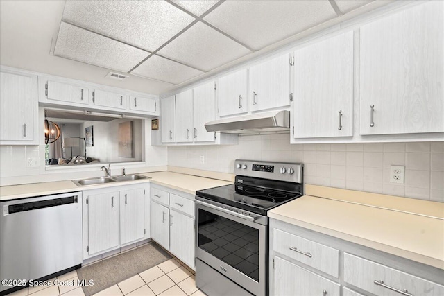 3170 N Atlantic Ave Unit 412, Cocoa Beach, FL 32931 - kitchen featuring appliances with stainless steel finishes, under cabinet range hood, a paneled ceiling, decorative backsplash, and light countertops