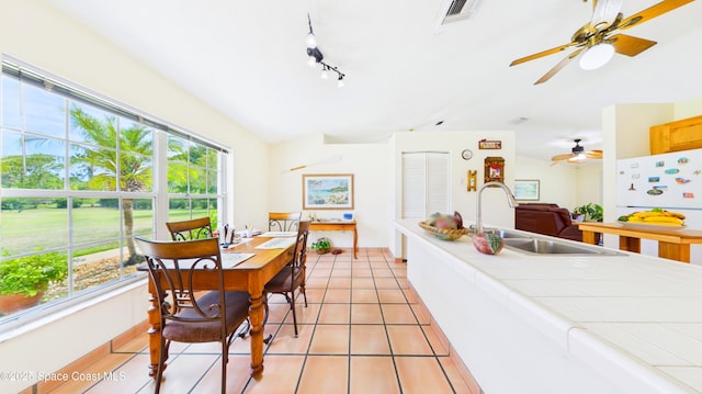 3200 Grant Rd, Grant-Valkaria, FL 32949 - dining area with healthy amount of natural light, light tile patterned floors, ceiling fan, and vaulted ceiling