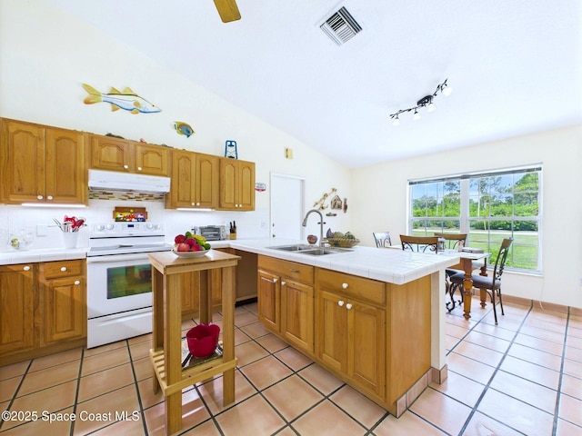 3200 Grant Rd, Grant-Valkaria, FL 32949 - kitchen with white range with electric cooktop, under cabinet range hood, light tile patterned floors, tile countertops, and lofted ceiling