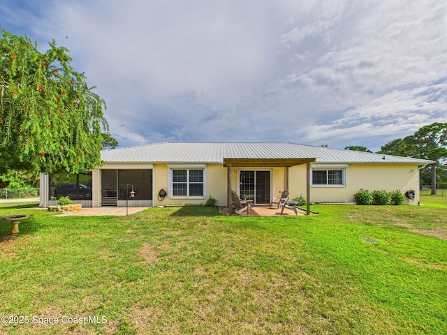 3200 Grant Rd, Grant-Valkaria, FL 32949 - rear view of property with a sunroom, stucco siding, a patio, and a lawn