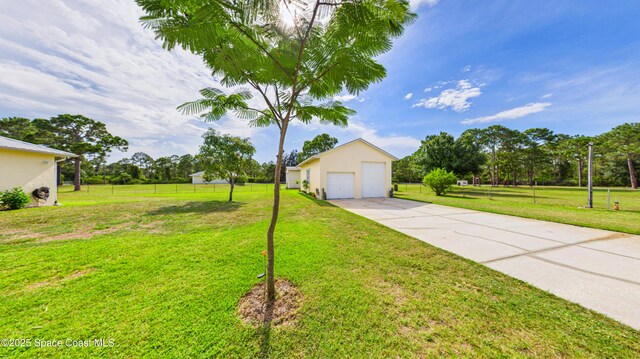 3200 Grant Rd, Grant-Valkaria, FL 32949 - view of front facade with stucco siding, concrete driveway, a detached garage, and an outbuilding