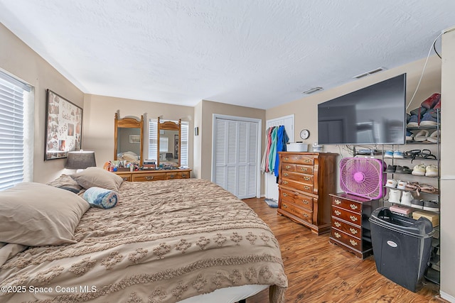 1714 Blanche Ave, Melbourne, FL 32934 - bedroom with wood finished floors, a textured ceiling, multiple windows, and a closet