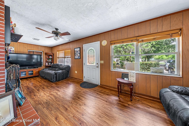 1714 Blanche Ave, Melbourne, FL 32934 - living area featuring wood finished floors, a ceiling fan, wooden walls, and a textured ceiling