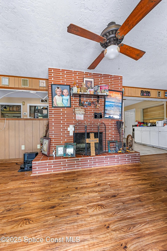 1714 Blanche Ave, Melbourne, FL 32934 - living room with wood finished floors, a textured ceiling, a ceiling fan, and a fireplace