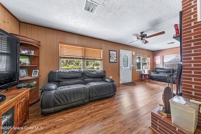 1714 Blanche Ave, Melbourne, FL 32934 - living area featuring a ceiling fan, wood finished floors, a textured ceiling, and wood walls