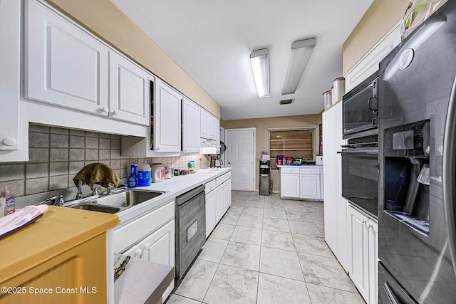 1714 Blanche Ave, Melbourne, FL 32934 - kitchen with black appliances, white cabinets, light marble finish flooring, light countertops, and decorative backsplash