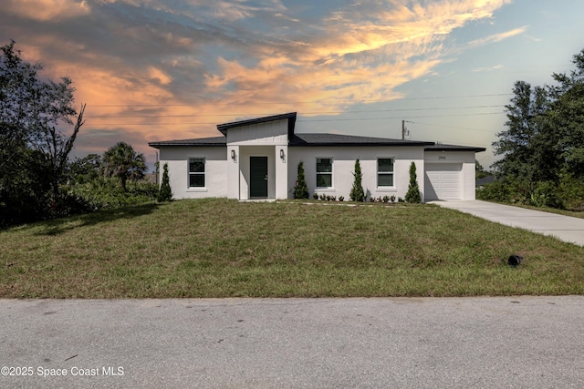 2943 Creech Ave SE, Palm Bay, FL 32909 - modern home featuring a garage, concrete driveway, a lawn, and stucco siding