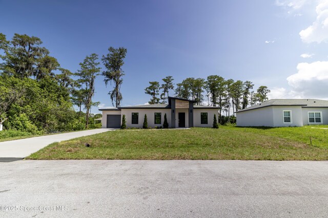 1326 Sagbloom St SE, Palm Bay, FL 32909 - view of front of house with concrete driveway, a garage, a front lawn, and stucco siding