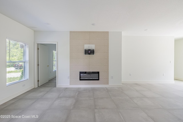 1326 Sagbloom St SE, Palm Bay, FL 32909 - unfurnished living room featuring baseboards and a tile fireplace