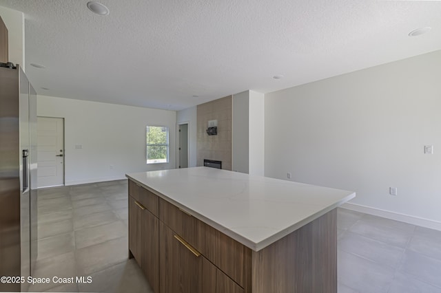 1326 Sagbloom St SE, Palm Bay, FL 32909 - kitchen with a textured ceiling, modern cabinets, a center island, a tiled fireplace, and open floor plan