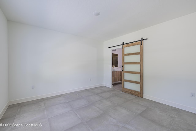 1326 Sagbloom St SE, Palm Bay, FL 32909 - empty room featuring a barn door and baseboards