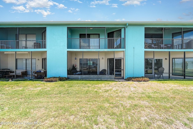 2880 S Atlantic Ave Unit 102, Cocoa Beach, FL 32931 - rear view of house featuring stucco siding and a lawn