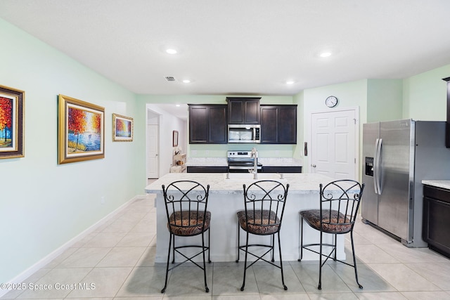 3724 Sandhill Crane Cir, Mims, FL 32754 - kitchen featuring stainless steel appliances, recessed lighting, light tile patterned floors, a kitchen bar, and a kitchen island with sink