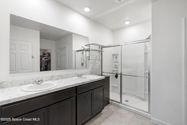 3724 Sandhill Crane Cir, Mims, FL 32754 - bathroom featuring a shower stall, a spacious closet, tile patterned flooring, and double vanity