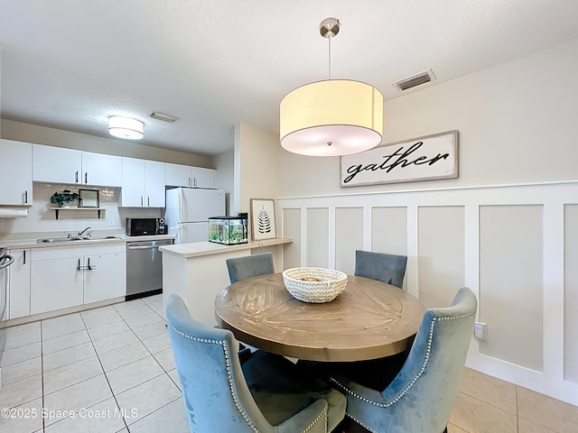 1870 Long Iron Dr Unit 1225, Rockledge, FL 32955 - dining space with light tile patterned flooring, wainscoting, and a decorative wall