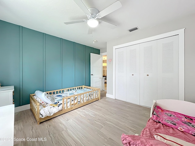 1870 Long Iron Dr Unit 1225, Rockledge, FL 32955 - bedroom featuring a decorative wall, light wood finished floors, a closet, and ceiling fan