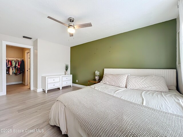 1870 Long Iron Dr Unit 1225, Rockledge, FL 32955 - bedroom with light wood-style floors, a spacious closet, a ceiling fan, and a closet