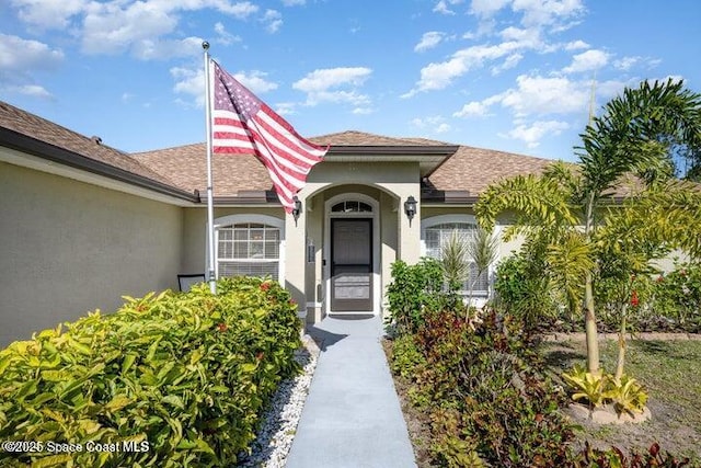 793 Ontario St NW, Palm Bay, FL 32907 - view of exterior entry featuring stucco siding and a shingled roof