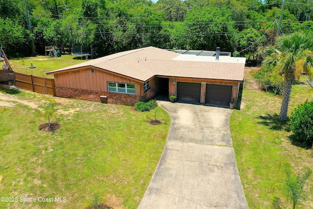 614 W Ct, Titusville, FL 32796 - view of front of home with a garage, concrete driveway, a trampoline, brick siding, and board and batten siding