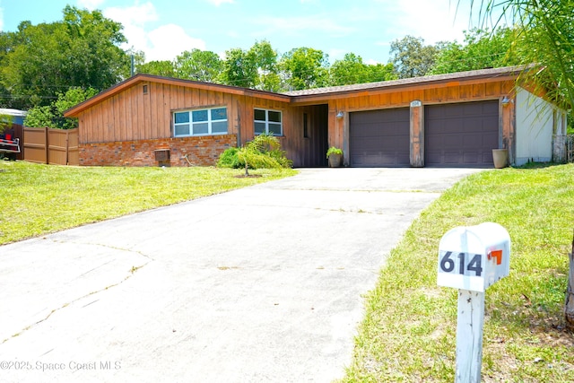 614 W Ct, Titusville, FL 32796 - ranch-style house featuring an attached garage, driveway, and board and batten siding