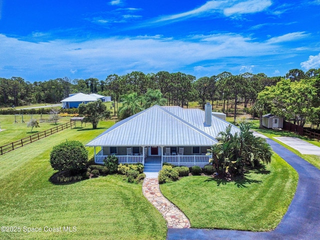 6025 Brabrook Ave, Grant, FL 32949 - view of front facade with a chimney, covered porch, a metal roof, and view of scattered trees