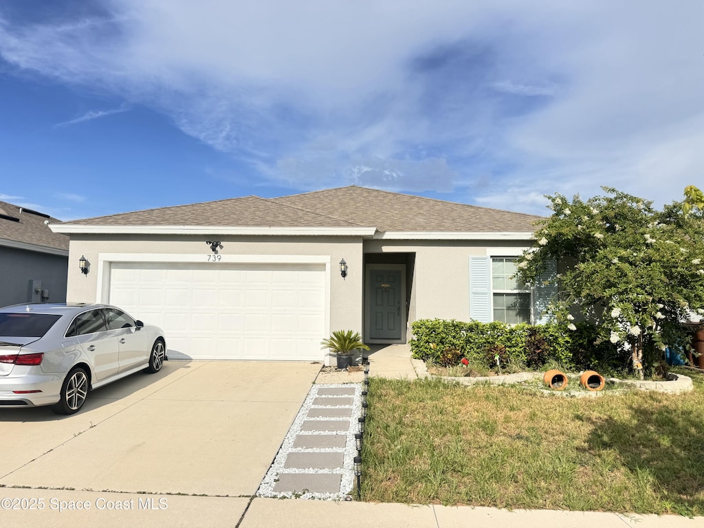739 Jefferson St, Davenport, FL 33837 - ranch-style home featuring driveway, an attached garage, stucco siding, roof with shingles, and a front yard