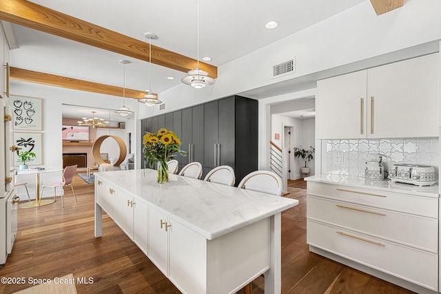 2600 N Riverside Dr, Indialantic, FL 32903 - kitchen with a breakfast bar area, tasteful backsplash, white cabinetry, recessed lighting, and decorative light fixtures