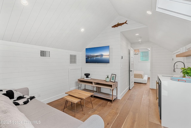 2600 N Riverside Dr, Indialantic, FL 32903 - living area featuring light wood-style flooring, lofted ceiling, wooden walls, and recessed lighting