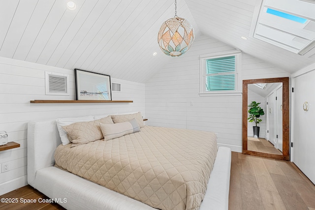 2600 N Riverside Dr, Indialantic, FL 32903 - bedroom featuring light wood finished floors, lofted ceiling, wood walls, a skylight, and recessed lighting