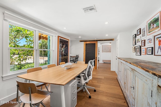 2600 N Riverside Dr, Indialantic, FL 32903 - home office with a barn door, light wood-style flooring, and recessed lighting