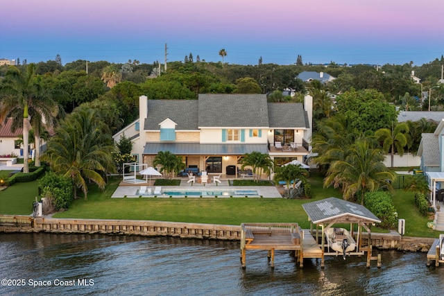 2600 N Riverside Dr, Indialantic, FL 32903 - back of property with a balcony, an outdoor pool, a water view, and a patio
