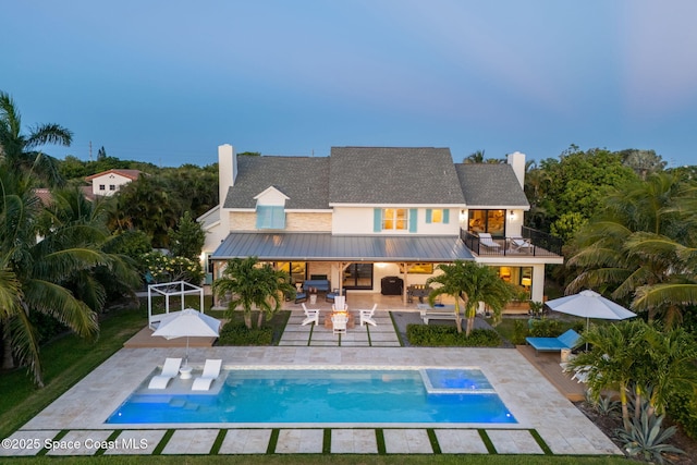 2600 N Riverside Dr, Indialantic, FL 32903 - back of property featuring a standing seam roof, a balcony, a patio, outdoor dining space, and a chimney