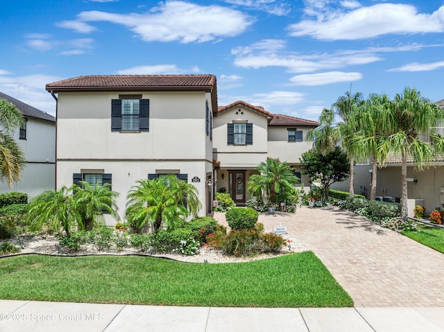 7873 Desmond Ave, Melbourne, FL 32940 - mediterranean / spanish house with a tile roof, stucco siding, and a front lawn